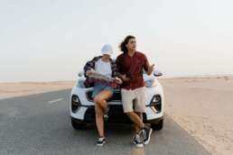 couple sitting in front of a rented car-car rental