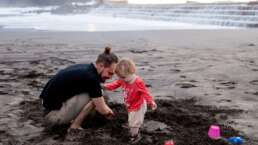 a kid and father playing on a beach